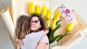 Mujer abraza a otra mujer con un fondo floral.