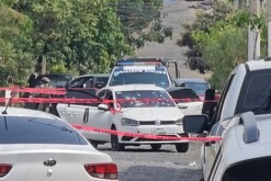 Auto Volkswagen blanco con balazos en el parabrisas con una patrulla de Zapopan, policías y militares alrededor