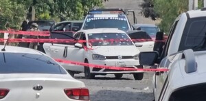 Auto Volkswagen blanco con balazos en el parabrisas con una patrulla de Zapopan, policías y militares alrededor