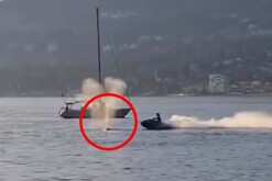 Hombre en moto acuática a punto de chocar contra una ballena gris en aguas de Canadá con una embarcación detrás
