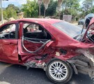 Automóvil color rojo destrozado de la puerta trasera y la cajuela en medio de una carretera de Tala con un policía enfrente