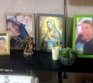 Fotografía de Luis Fernando Cervantes Moya y de la Virgen de Guadalupe en portaretratos sobe una mesa de madera