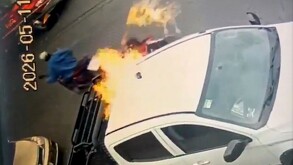 Hombre prendiendo fuego a una camioneta blanca tipo pickup estacionada en Guadalajara con otro hombre en una motocicleta detrás