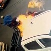 Hombre prendiendo fuego a una camioneta blanca tipo pickup estacionada en Guadalajara con otro hombre en una motocicleta detrás