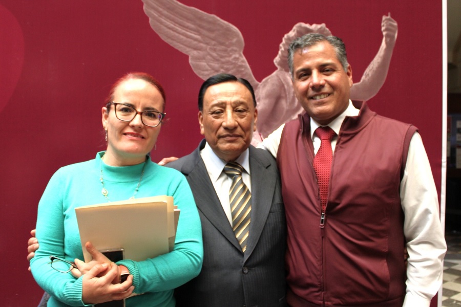 Dos hombres y una mujer sonriendo para una fotografía.