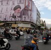 Motocicletas pasan ante un cartel que muestra una imagen del fallecido líder supremo de irán, el ayatolá Alí Jamenei, fallecido en ataques de Estados Unidos.