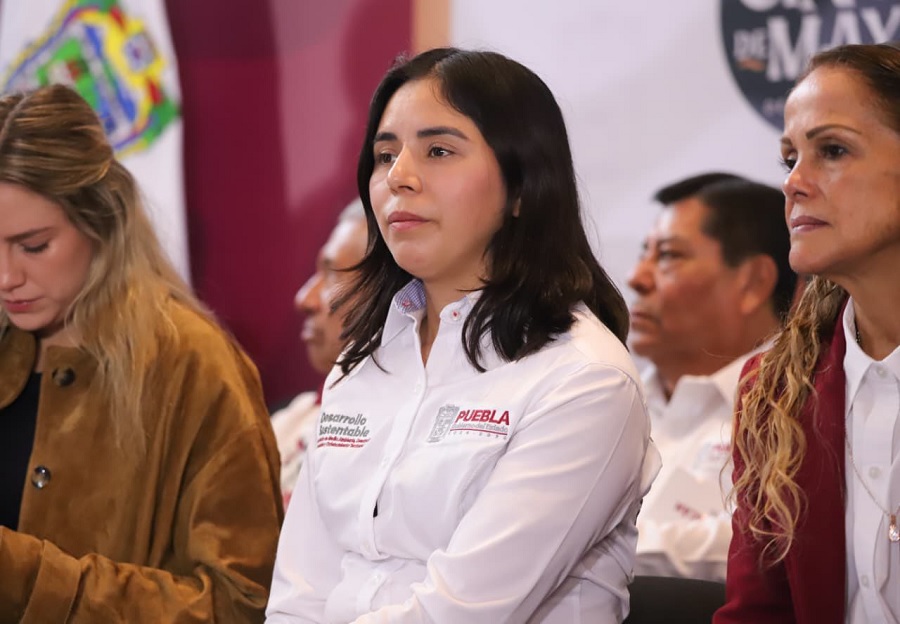Tres mujeres escuchando una conferencia de prensa de Morena.