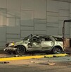 Se observa un carro color gris destruido  y una patrulla a un lado; es de noche.