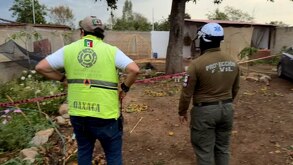 Elementos de protección civil observan un terreno asegurado con cinta preventiva.