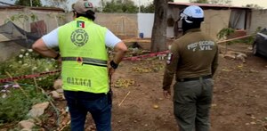 Elementos de protección civil observan un terreno asegurado con cinta preventiva.