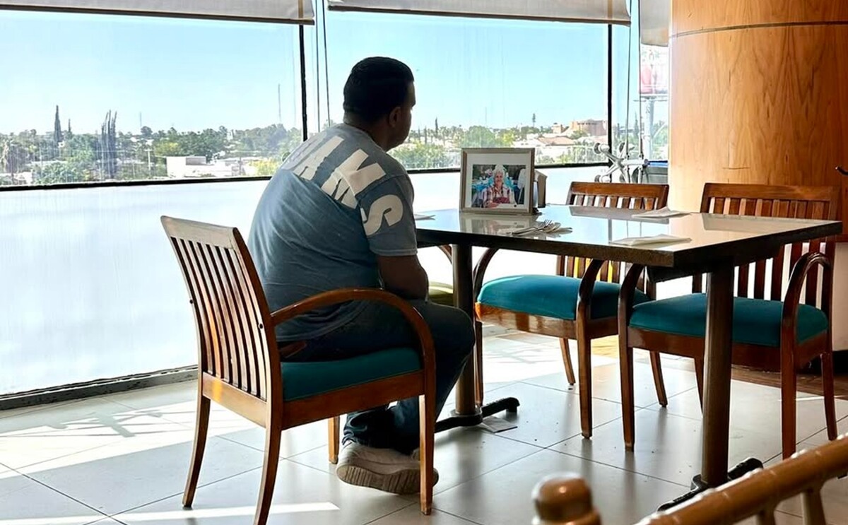 Joven que fue captado desayunando con la fotografía de su mamá en el Día de las Madres.