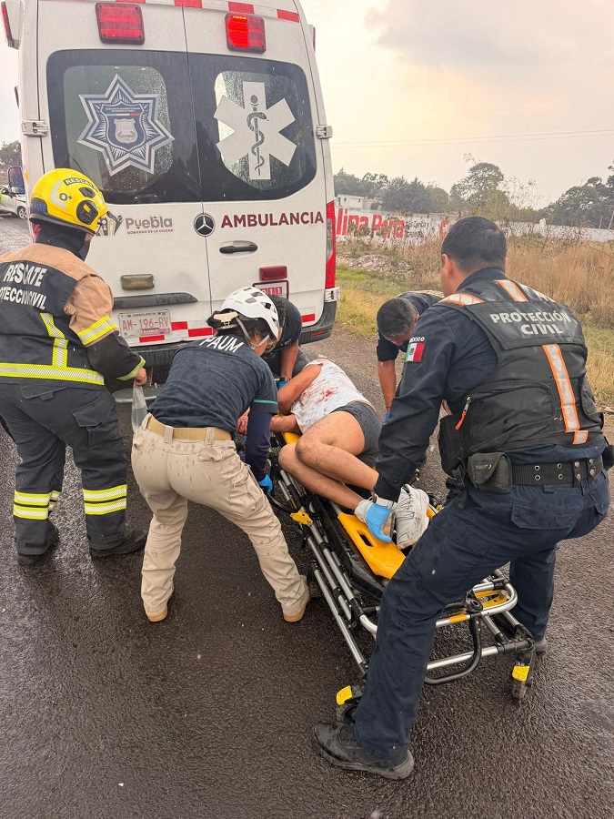 Personal de emergencias atiende a una persona herida en una carretera.