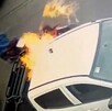 Hombre prendiendo fuego a una camioneta blanca tipo pickup estacionada en Guadalajara con otro hombre en una motocicleta detrás