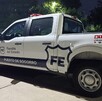 Patrulla blanca de la Fiscalía del Estado de Jalisco estacionada detrás de una patrulla de la Policía de Guadalajara al lado de áreas verdes
