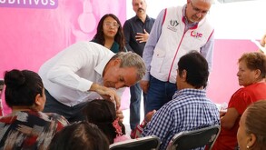 Pepe Chedraui le pone una prótesis auditiva a una niña durante el evento en Puebla