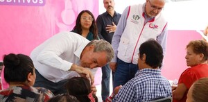 Pepe Chedraui le pone una prótesis auditiva a una niña durante el evento en Puebla