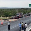 Se observan a varias personas y una camioneta destrozada del frente, en la carretera.