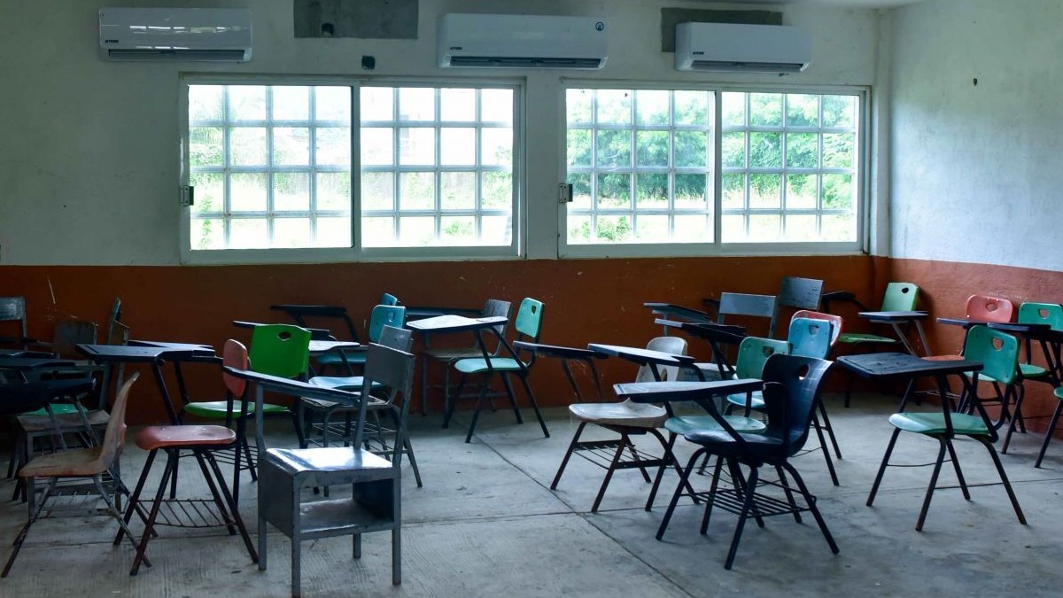 Se observan unas butacas dentro de un salón de clases.