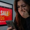 Mujer ve su celular con cara de asombro porque fue estafada en el Hot Sale 2026