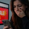 Mujer ve su celular con cara de asombro porque fue estafada en el Hot Sale 2026
