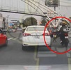 autos esperan en un auto y un motociclista se aproxima a un niño que camina entre los carros
