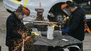dos hombres operan maquinaria en una fábrica de autos