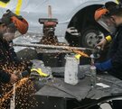 dos hombres operan maquinaria en una fábrica de autos