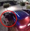 Hombre apuntando a una mujer dentro de un camioneta azul con la puerta del conductor abierta al exterior de una casa en Zapopan