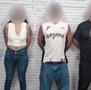 Se observa a dos hombres y una mujer con el rostro cubierto y están parados.