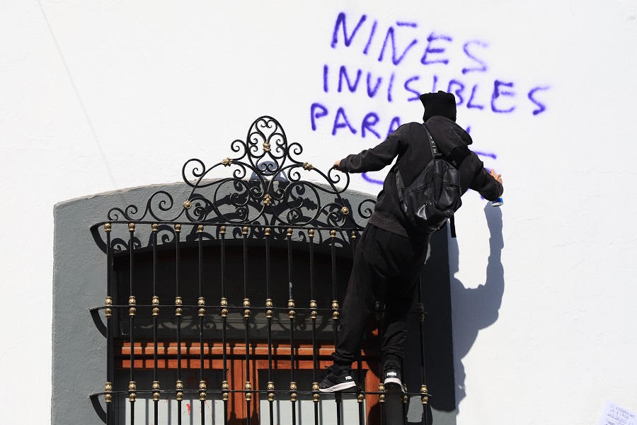 Hombre pintando una pared a favor de las infancias trans.