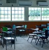 Se observan unas butacas dentro de un salón de clases.