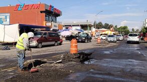 una persona arregla un bache en una calle en puebla