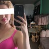 Imagen de Valeria Márquez con los ojos censurados por un recuadro blanco sosteniendo su celular con una imagen del interior de su salón de belleza de fondo