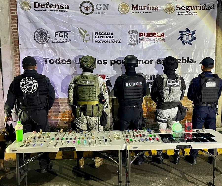 Fuerzas de seguridad junto a objetos decomisados en una cárcel de Puebla.