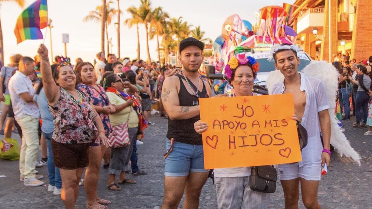 Mujer sosteniendo cartel de apoyo a la comunidad LGBT en Puerto Vallarta