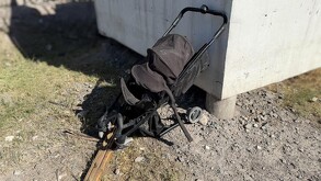Se observa una carriola negra destruida en una zona de piedras.