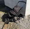 Se observa una carriola negra destruida en una zona de piedras.