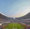 Estadio Banorte visto desde adentro en vista panorámica. Tribunas semivacías. En la cancha algunos jugadores entrenan previo al inicio de un partido.
