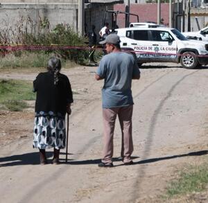 Autoridades acordonan el área donde se encuentra el cuerpo tapado con una manta azul