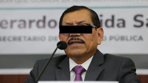 Foto de Gerardo Mérida Sánchez en una encuentro con los medios. La foto tiene una edición para taparle los ojos con una cinta negra.