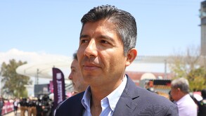 Foto de un hombre de camisa y traje visto desde un perfil.