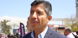 Foto de un hombre de camisa y traje visto desde un perfil.