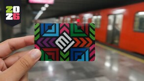Mano sujetando una tarjeta de movilidad frente al metro