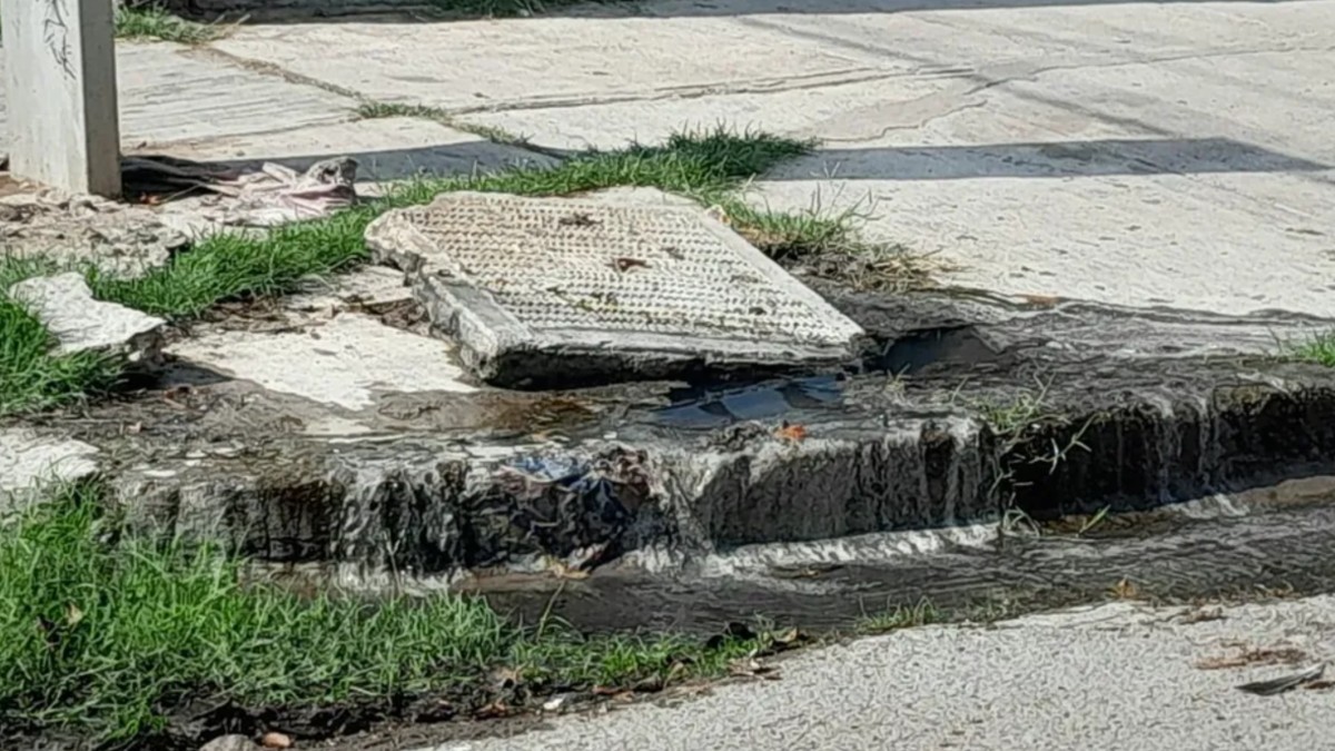 Imagen de una alcantarilla con fuga de agua negras en una esquina de una calle de Gómez Palacio