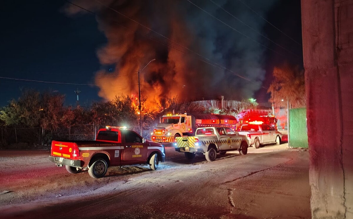 Bomberos sofocando el incendio en una bodega de una empresa en el Parque Industrial Oriente de Torreón.