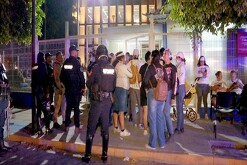 Miembros del colectivo Guerreros Buscadores de Jalisco al lado de policías del estado fuera del IJCF