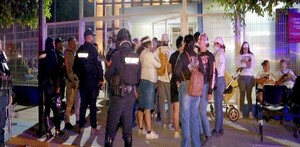 Miembros del colectivo Guerreros Buscadores de Jalisco al lado de policías del estado fuera del IJCF