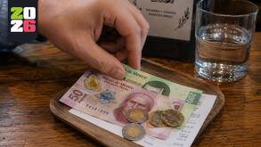 Imagen de una mano dejando propina en un restaurantes