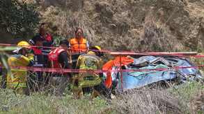 rescatistas intentan liberar a cuatro jóvenes atrapados en un auto que cayó de un barranco