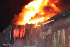 Columna de fuego y humo saliendo del interior de una fábrica de dulces en Zapopan con paredes de lámina alrededor